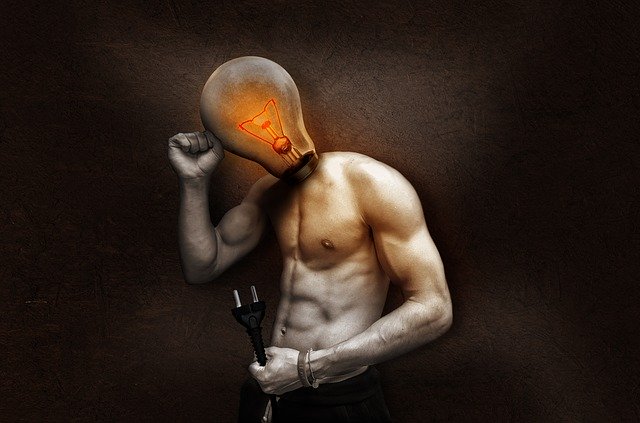 Svalnatý muž, ktorý má na miesto hlavy žiarovku a drží kábel v ruke.jpg